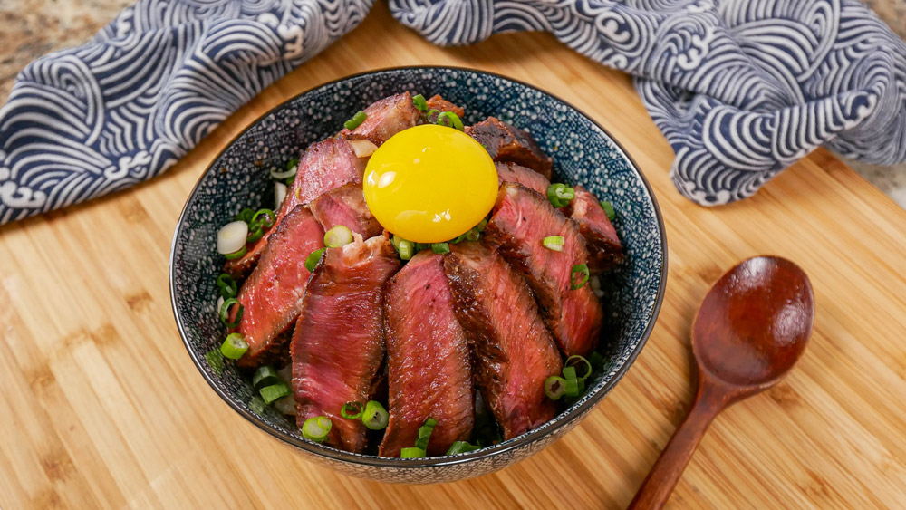 steak donburi rice bowl with egg yolk on top