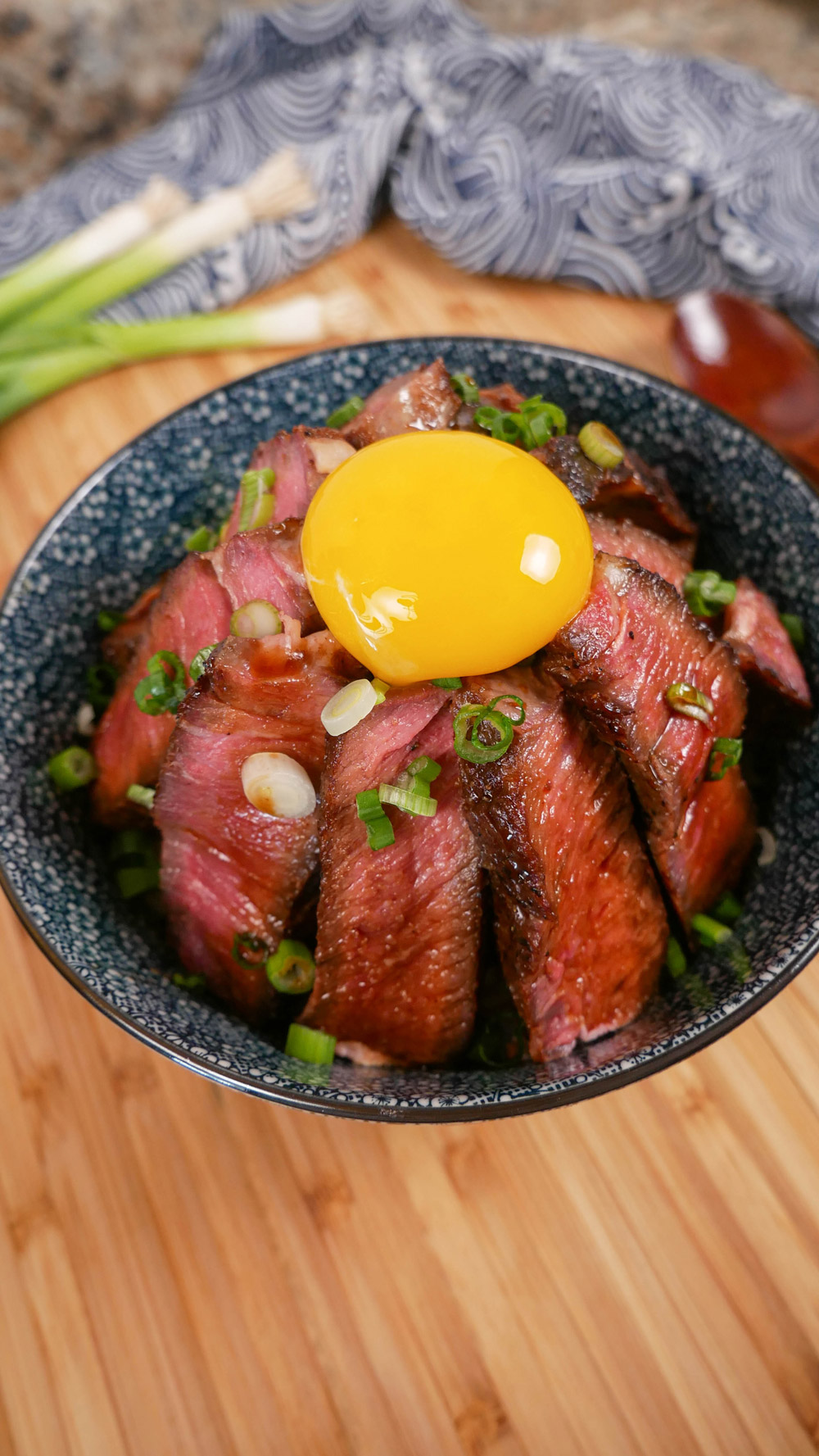 steak donburi rice bowl with egg yolk on top of rice bowl